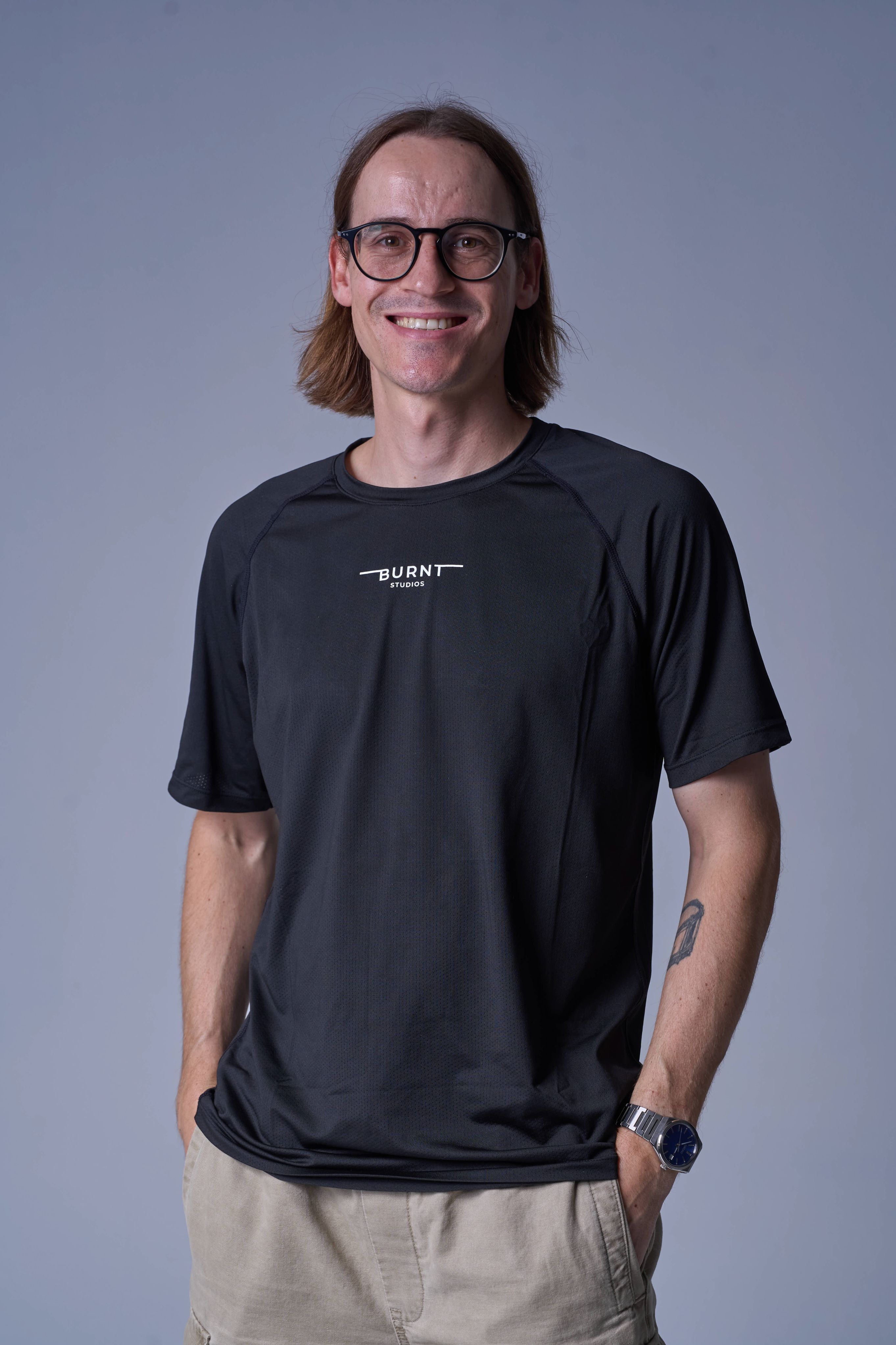 Kyle van Niekerk, black-and-white studio portrait, wearing glasses and a Burnt Studios t-shirt